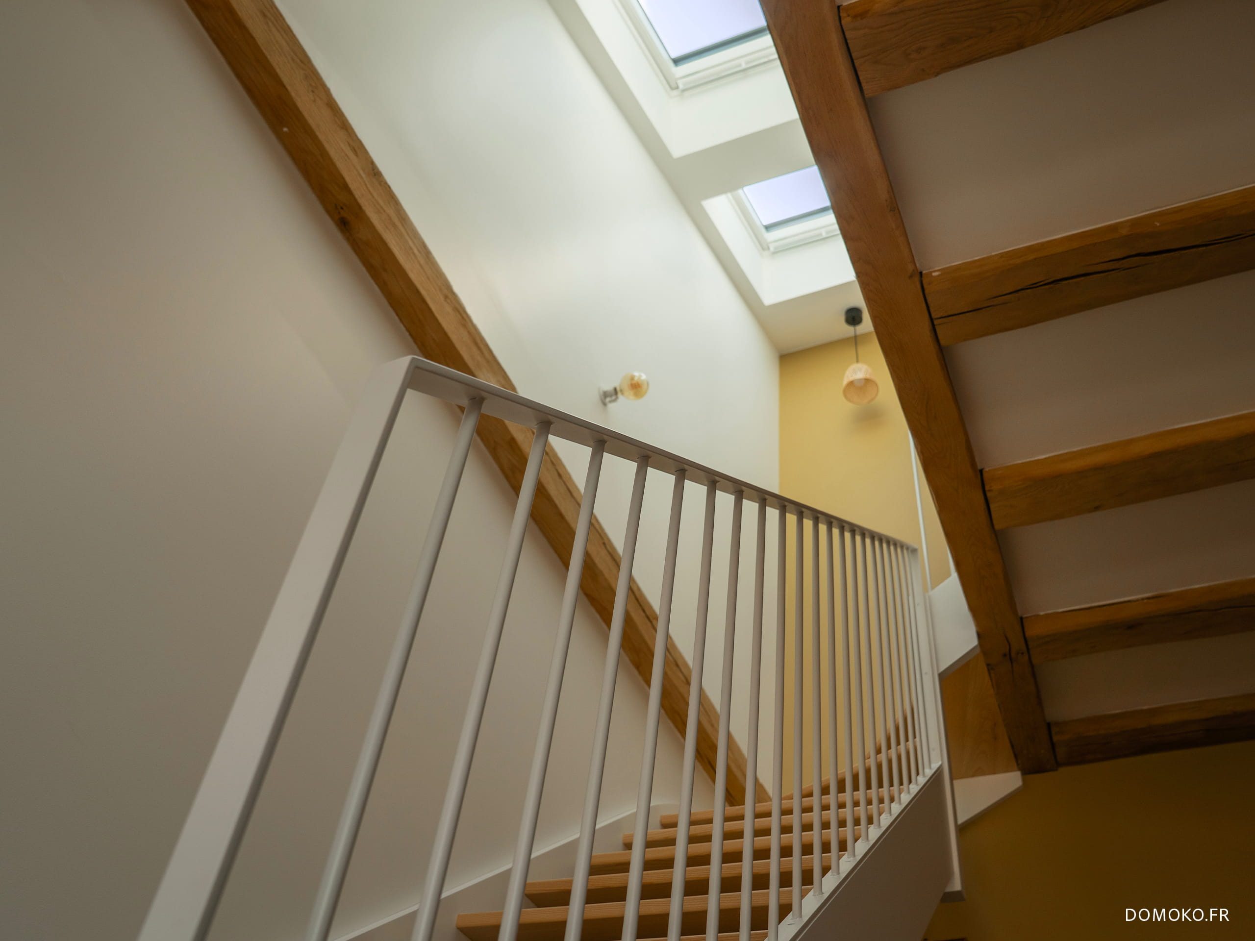 Escalier acier et bois, création d'une trémie avec des poutres en chêne et ajout de fenêtres de toit pour apporter un éclairage naturel dans la cage d'escalier