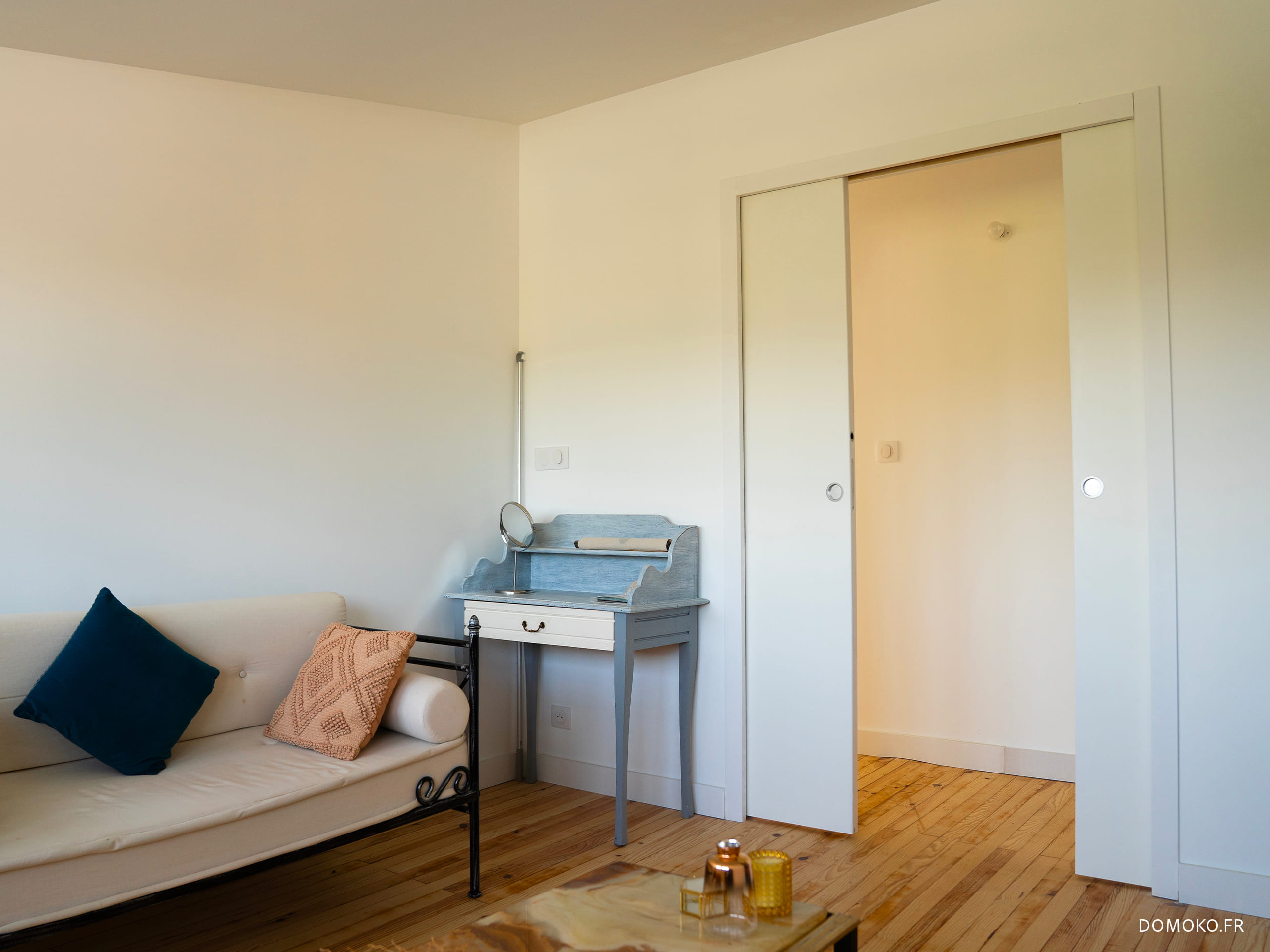 Création d'une pièce mixte petit-salon/chambre d'ami avec une porte à galandage double. Rénovation du parquet existant avec remplacement des lames abîmées.