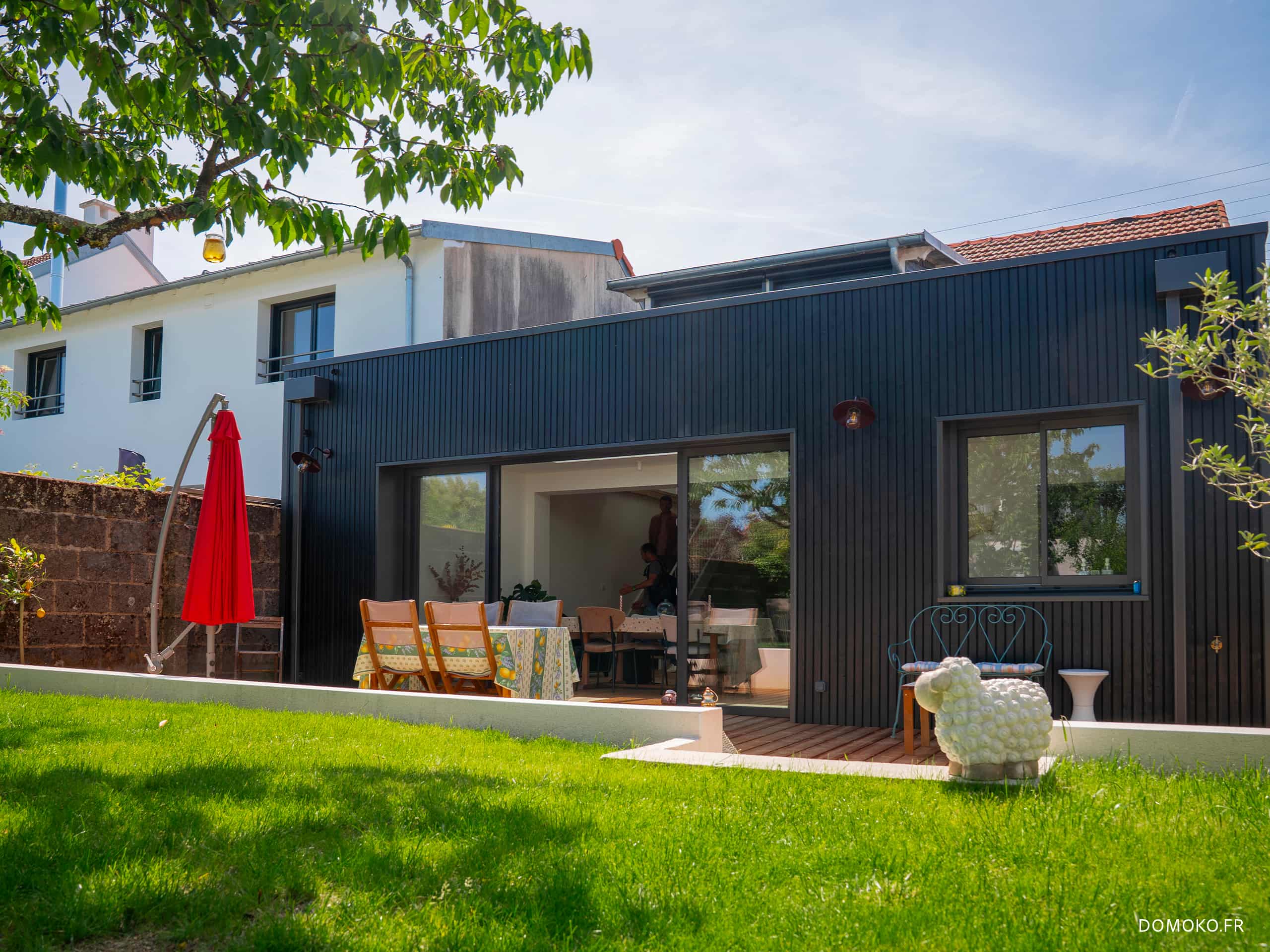Extension d'une maison en ossature bois avec bardage bois, verrière et baie 4 m sur terrasse bois